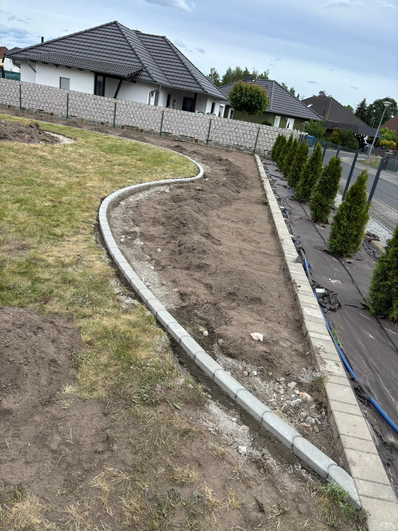 Neue Beeteinfassung mit Randsteinen auf einem Grundstück am Neubau