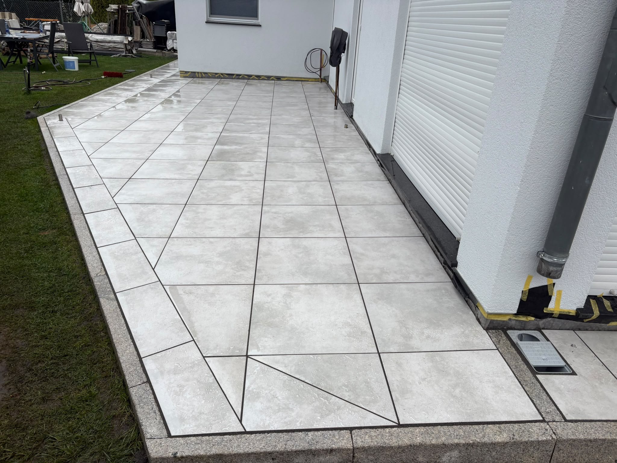 Terrasse aus großformatigen Keramikplatten an einer Hausecke