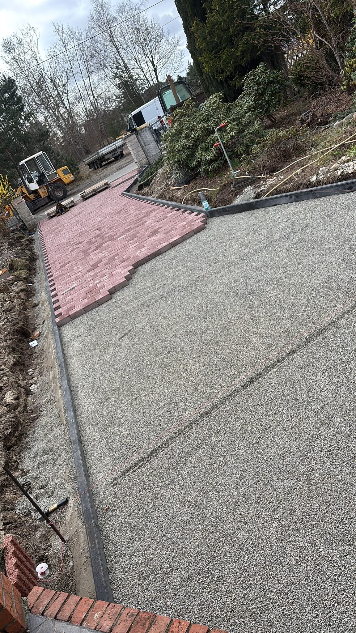 Neue befestigte Fläche mit rotem Pflasterstreifen